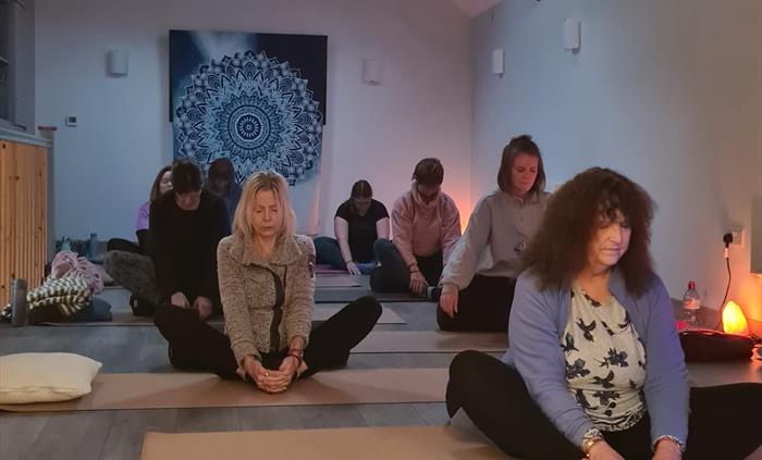 Group of people practising yoga at a wellbeing property.